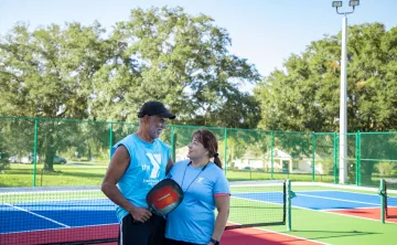 man woman on pickleball court looking at each other